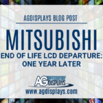 A promotional banner for an AGDisplays blog post on a grid background of various images. The banner is titled "MITSUBISHI END OF LIFE LCD DEPARTURE: ONE YEAR LATER" in a large, dark blue font. The AGDisplays logo and website "www.agdisplays.com" are at the bottom of the banner.